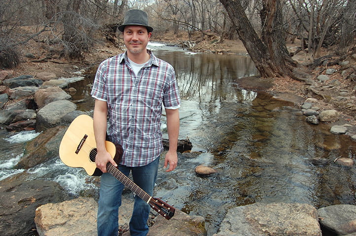 Photo of Andy Schiller holding a guitar