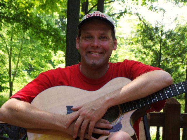 Photo of Barry Brickey holding a guitar