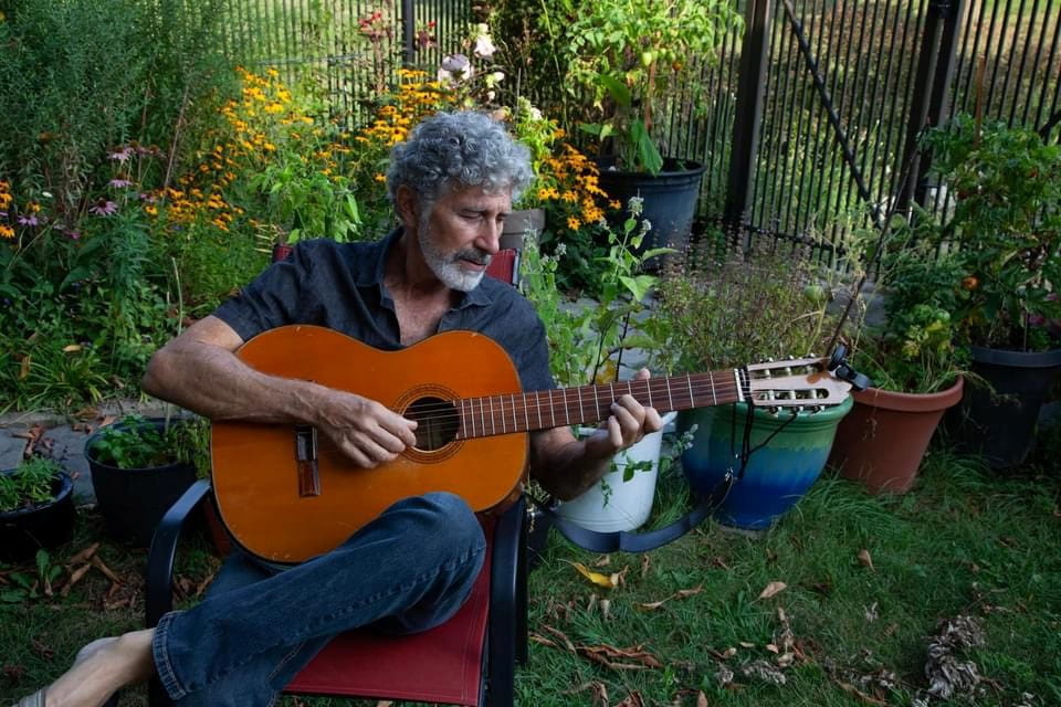 Photo of Steve Rich playing a guitar